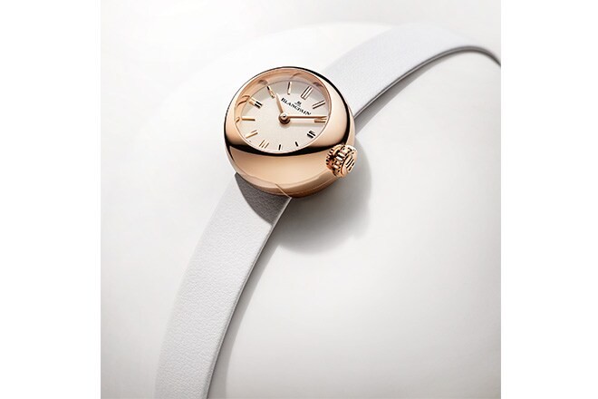 A red gold Lady B resting on a curved surface