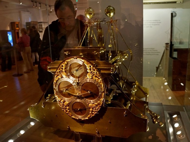 Harrison's first marine timekeeper H1, a large brass machine with linked balances, in a glass case
