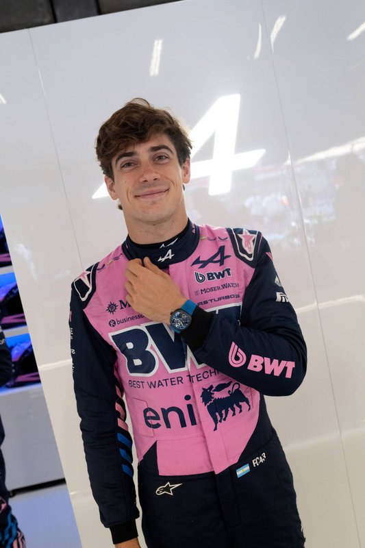 A young Alpine driver in a pink race suit wearing the watch